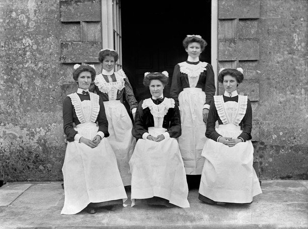 Servants at Biddlesden Park House, Buckinghamshire, c1896-c1920. (Photo by English Heritage/Heritage Images/Getty Images) A black and white photo of five servants in Edwardian serving dress