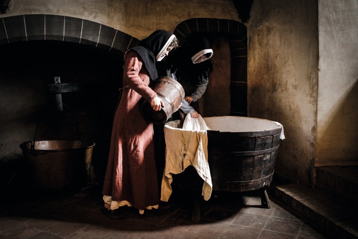 Historical re-enactment of two maids washing clothes in Italy. (Photo by DeAgostini via Getty Images) A photograph of two