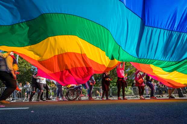 People march with a large rainbow flag in Reykjavik, Iceland. (Image by Photolibrary / Getty Images Plus)