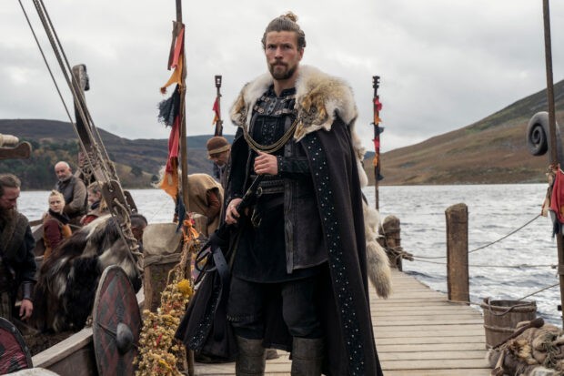 Harald Sigurdsson (Leo Suter) in Vikings Valhalla (Photo by Bernard Walsh/Netflix) Harald Sigurdsson stands on a dock in Kattegat holding a weapon